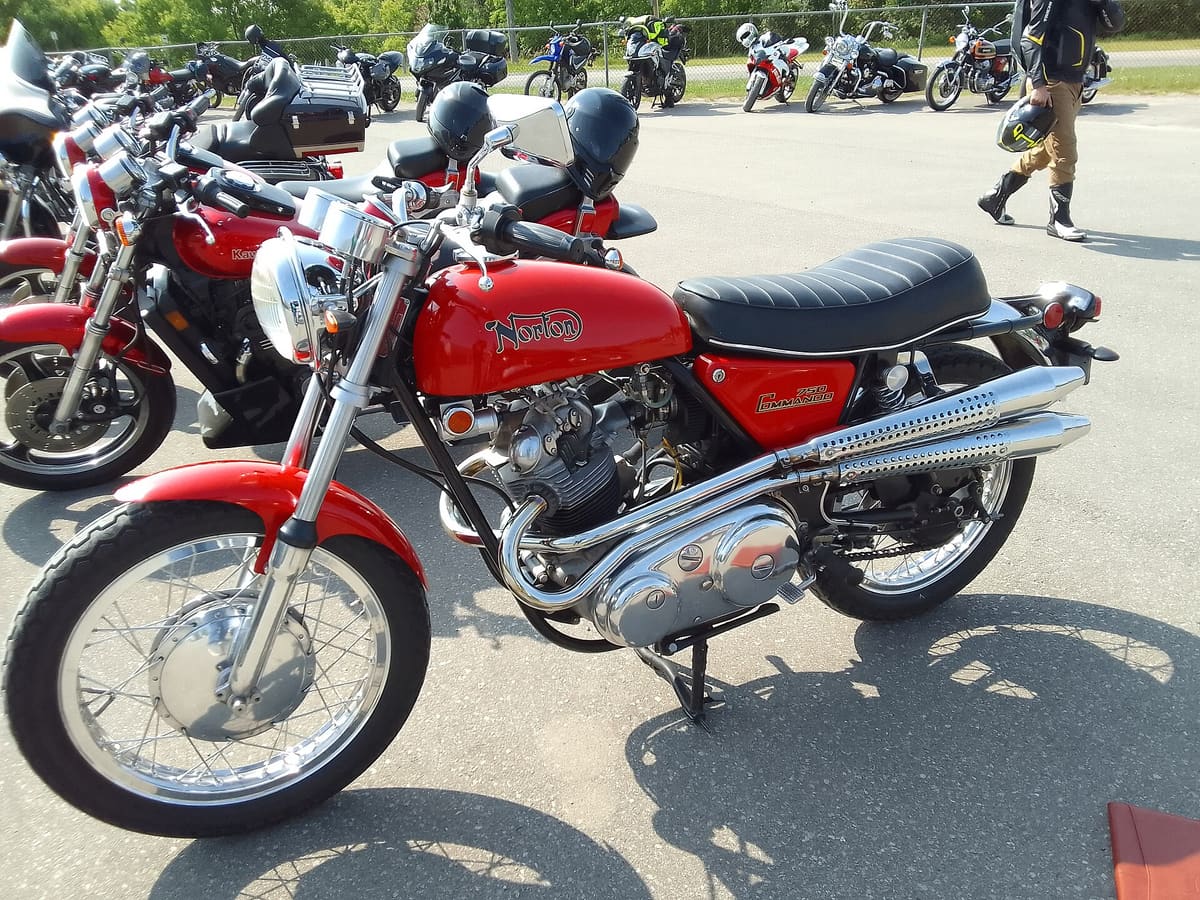 A red 1970 Norton Commando motorcycle parked in the sun