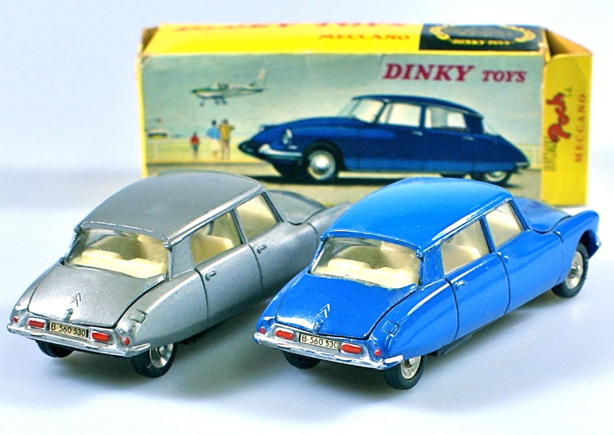 Two vintage die-cast Dinky Toys Citroën cars in front of their box